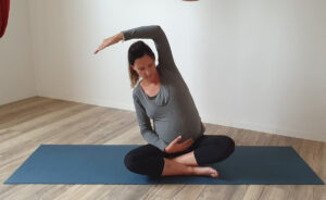 Schwangere Frau übt Yoga im Sitzen